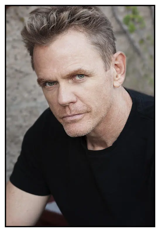 Blue-eyed man against brick background